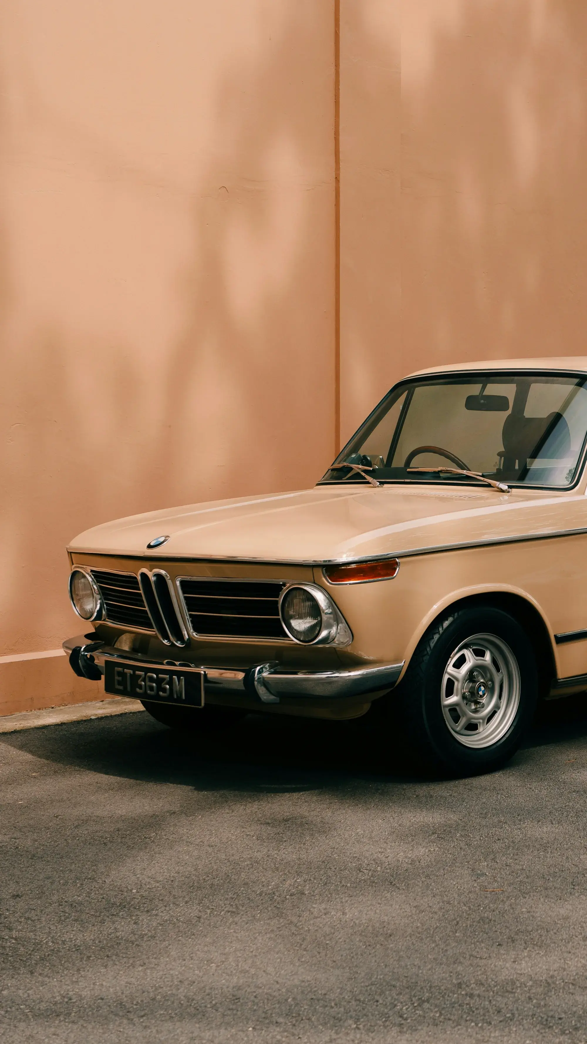 Classic BMW in front of a peach wall
